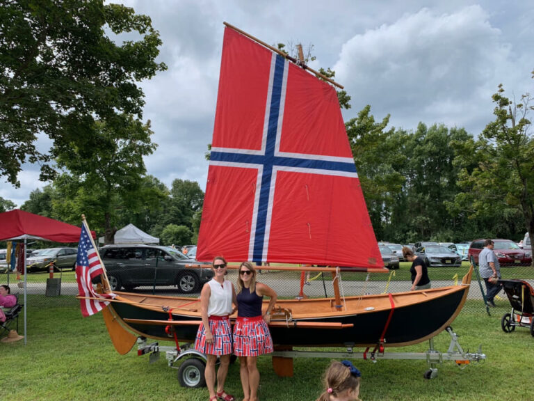 attendees posing with a boat