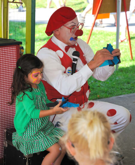 girl sitting next to clown