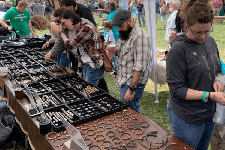 people looking at jewelry on a table